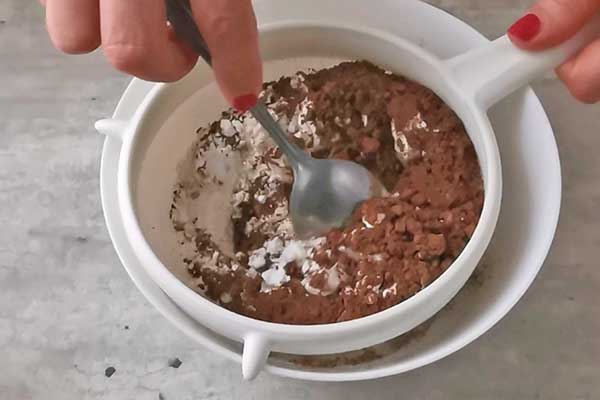 przesiewanie mąki z gorzkim kakao na czekoladowy biszkopt