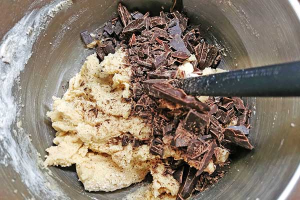 dodawanie posiekanej czekolady do ciasta na ciastka czekoladowe
