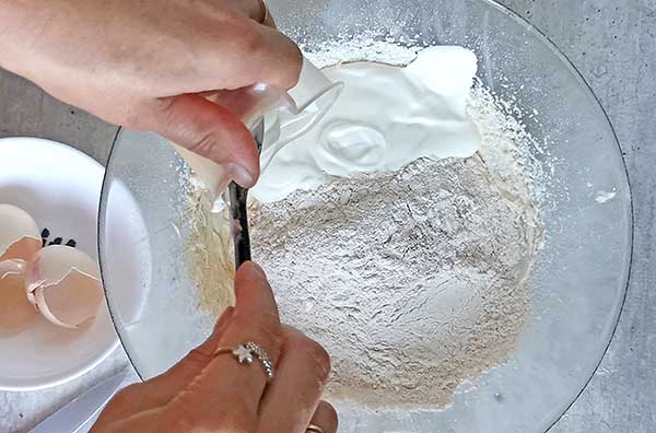 dodawanie mąki i jogurtu do ucieranego ciasta