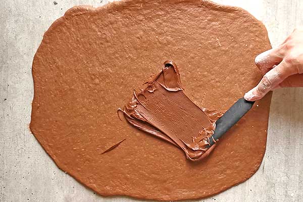 smarowanie czekoladowego ciasta drożdżowego nutellą