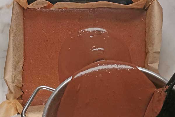 wylewanie czekoladowego ganache na sernik czekoladowy