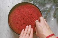nakładanie drugiego czerwonego blatu ciasta na tort
