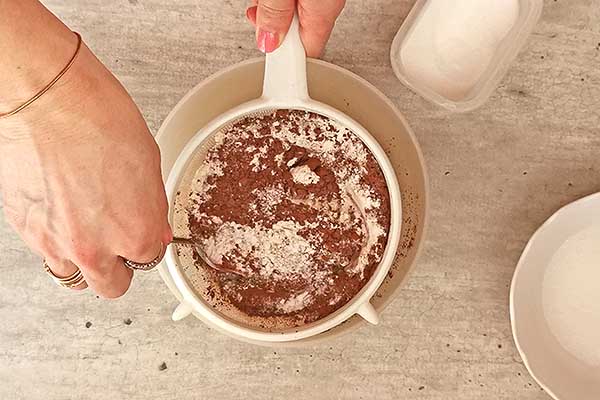 przesiewanie mąki z kakao przez sitko