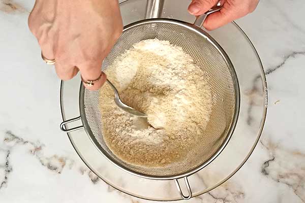 przesiewanie mąki z migdałami do ciasta