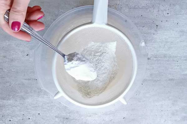 przesiewanie mąki przez sitko do przygotowania biszkopta