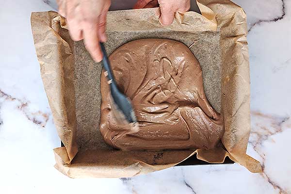 wykładanie biszkoptu czekoladowego do formy do pieczenia