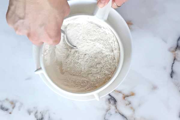 przesiewanie mąki przez sitko