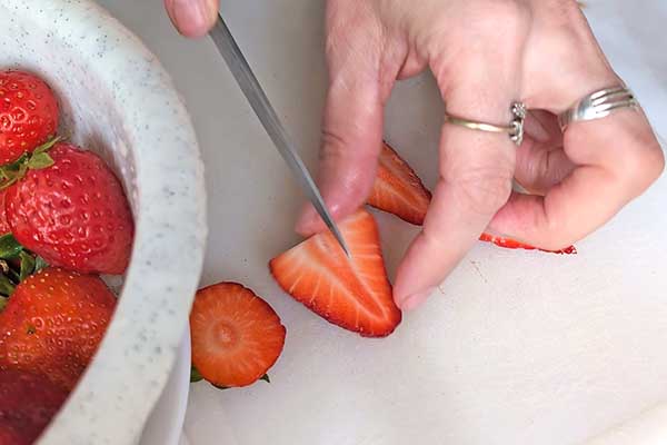 pokrój truskawki na mniejsze kawałki aby je dodać do ciasta