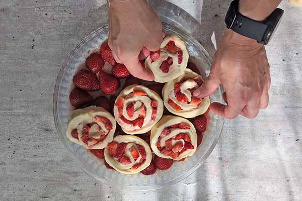 układanie bułeczek drożdżowych z truskawkami w formie do pieczenia