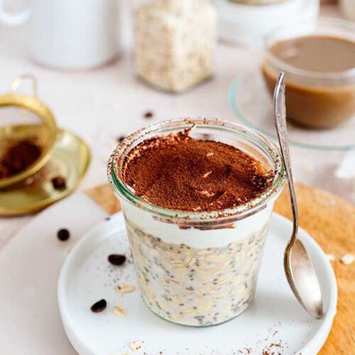 a glass jar with oatmeal and a spoon on a plate