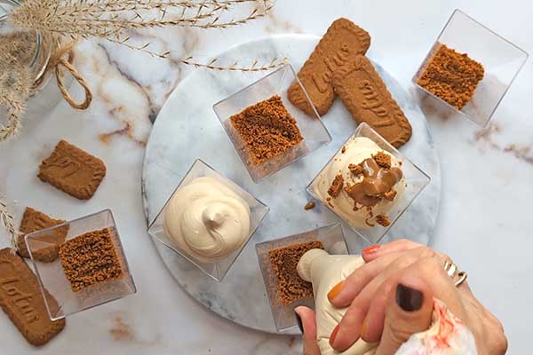 nakładanie kremu mascarpone z biscoff do przygotrowanych pucharków