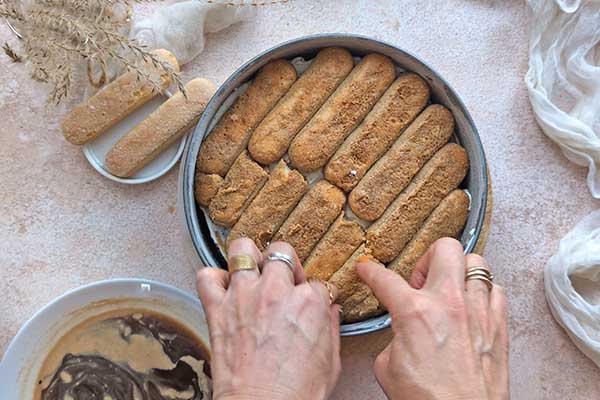 układanie w formie namoczonych w kawie biszkoptów do tiramisu