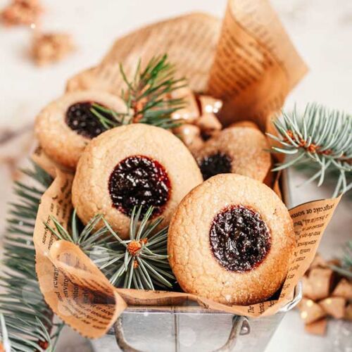 a small metal bucket with cookies and pine branches