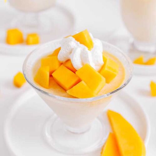 mango panna cotta z kawałkami mango i bitą śmietaną