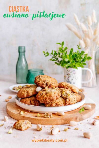 Ciastka owsiano-pistacjowe a plate of cookies on a wooden board