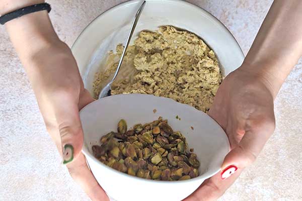 dodawanie posiekanych pistacji do ciasta na ciastka owsiane