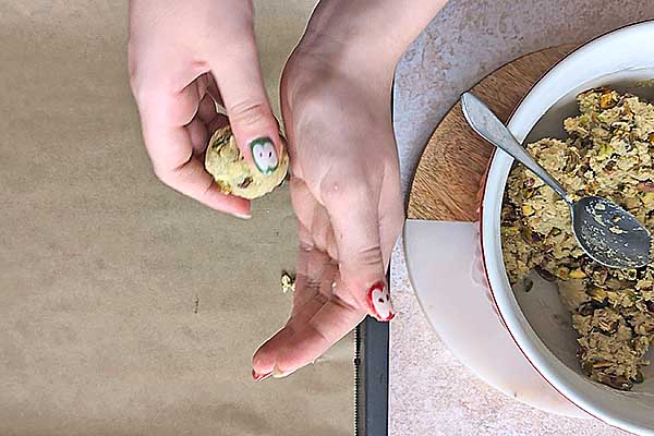 formowanie ciastek owsiano-pistacjowych przez turlanie ich w dłoniach