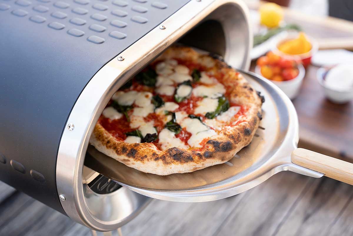 zdjęcie piecyka do wypieku pizzy wraz z upieczoną pizzą Jak wybrać idealny piecyk do pizzy do lokalu gastronomicznego?