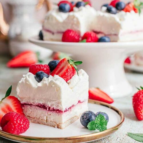 a cake with whipped cream and berries on a plate