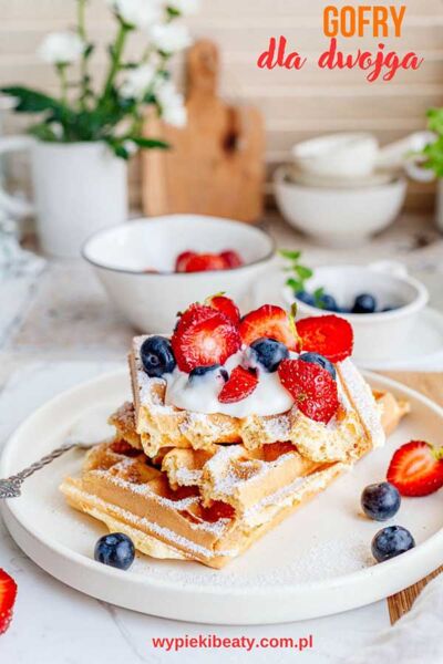 Przepis na gofry dla dwojga a plate of waffles with strawberries and blueberries