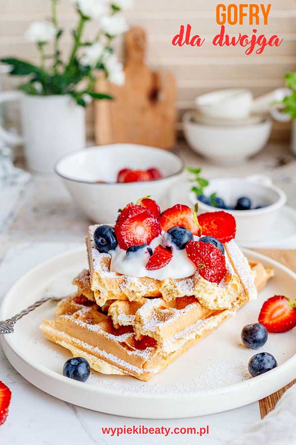 a plate of waffles with strawberries and blueberries