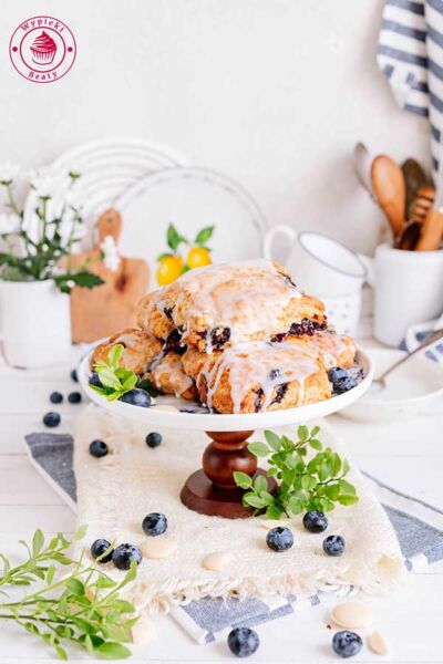 widok od przodu na paterę z ułożonymi na niej ciastkami scones z borówkami i białą czekoladą
