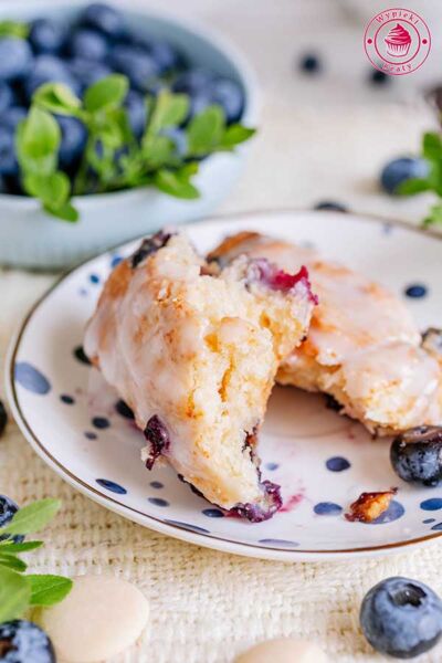 przełamane ciastko scones z borówkami leżące na małym talerzyku