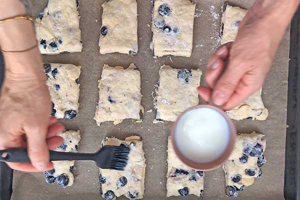 smarowanie pokrojonych scones mlekiem tuż przed ich pieczeniem