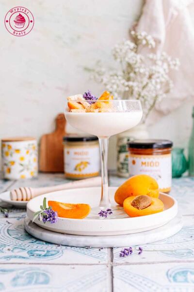 kieliszek z porcją deseru panna cotta z morelą i sezamkami