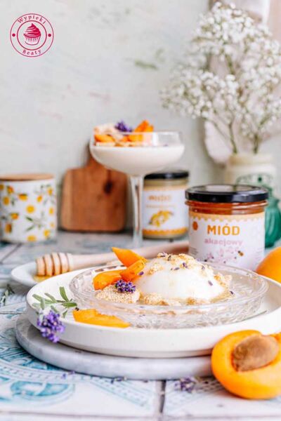 widok od przodu na porcję panna cotty w tle słoik z miodem