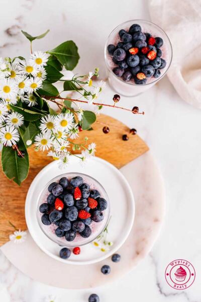 widok flat lay na pucharek z malinowym serniczkiem proteinowym