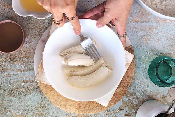 rozgniatanie bananów widelcem na ciasto z bananami i cukinią