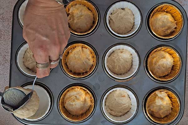 nakładanie porcji ciasta na muffinki do papilotek