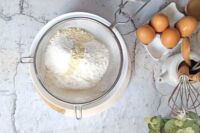 przesiewanie przez sito mąki z mielonymi migdałami