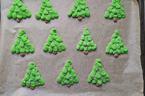 Kruche maślane ciastka choinki posypywanie ciasteczek choinek cukrowymi posypkami