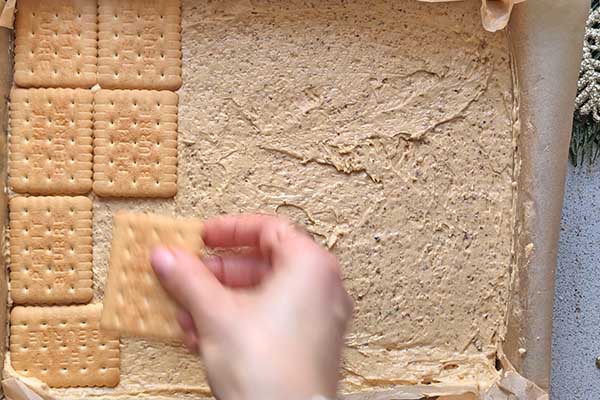 Ekspresowy miodownik bez pieczenia układanie herbatników na warstwie kremu kajmakowego