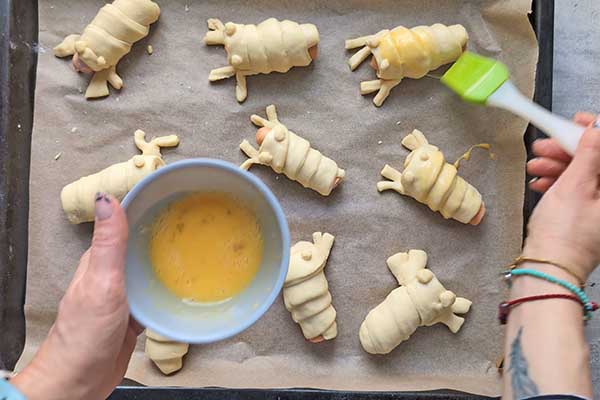 smarowanie parówek w cieście jajkiem przed ich pieczeniem