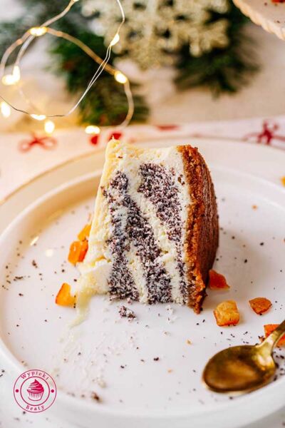 kawałek seromakowca z białą czekoladą i kandyzowaną skórką pomarańczową seromak świąteczny na spodzie z korzennych ciastek prosty przepis krok po kroku