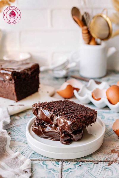 kawałki pokrojonego ciasta czekoladowego z czekoladową polewą przepis na jogurtowe ciasto z kakao i polewą czekoladową