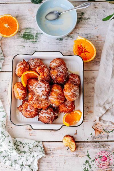 widok na usmażone pączusie z pomarańczą i pomarańczowym lukrem pomarańczowe pączki z serkiem ricotta prosty przepis