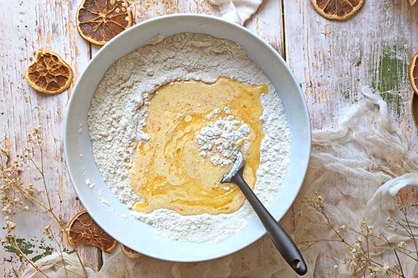 Pieczone oponki pomarańczowe mieszanie suchych składników na pączki pomarańczowe z mokrymi składnikami