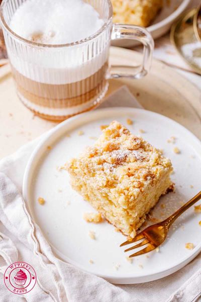 widok do góry po skosie na kawałek ciasta pomarańczowego z kruszonką w towarzystwie kawy z mlekiem proste ciasto pomarańczowe z kruszonką pomarańczową idealne do kawy