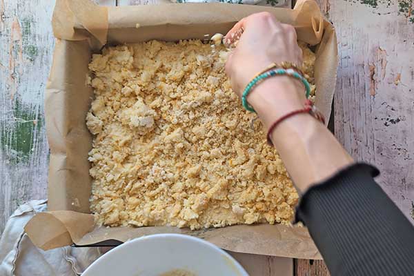 posypywanie ciasta pomarańczowego pomarańczową kruszonką