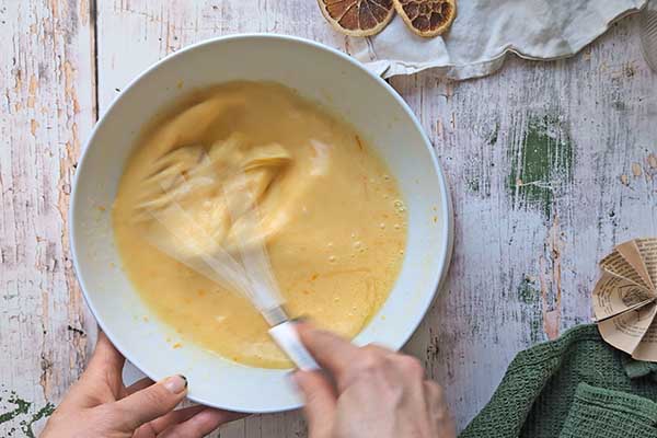 Pomarańczowe ciasto z makiem mieszanie mokrych składników na ciasto
