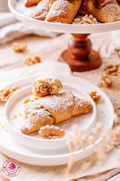 domowe chrupiące małe rogaliki z nadzieniem orzechowym obsypane cukrem pudrem kruche rogaliki z nadzieniem orzechowym obsypane cukrem pudrem