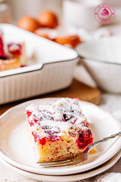 szybkie malinowe ciasto z lukrem i cukrem pudrem mieszane łyżką ciasto z malinami prosty przepis