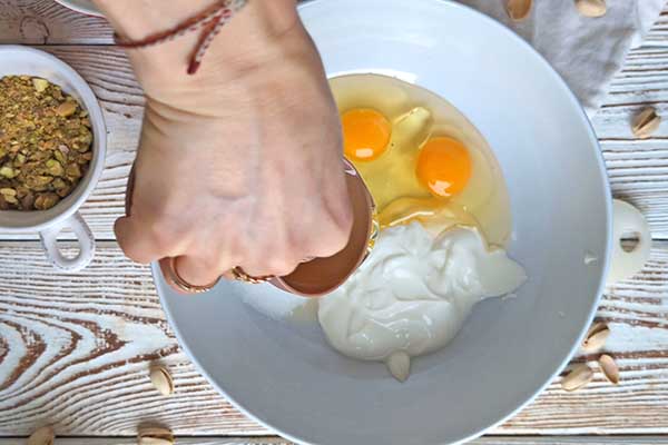 Ciasto marchewkowe z pistacjami mieszanie mokrych składników na ciasto marchewkowe z cukrem