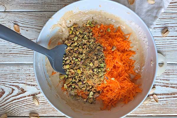 Ciasto marchewkowe z pistacjami mieszanie ciasta z tartą marchewką i posiekanymi pistacjami