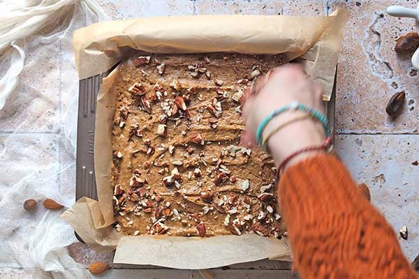 Daktylowe ciasto z orzechami posypywanie ciasta daktylowego posiekanymi orzechami