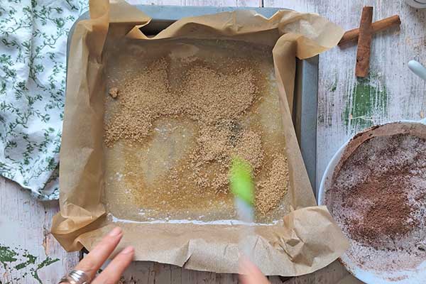 posypywanie dna formy do pieczenia cukrem trzcinowym